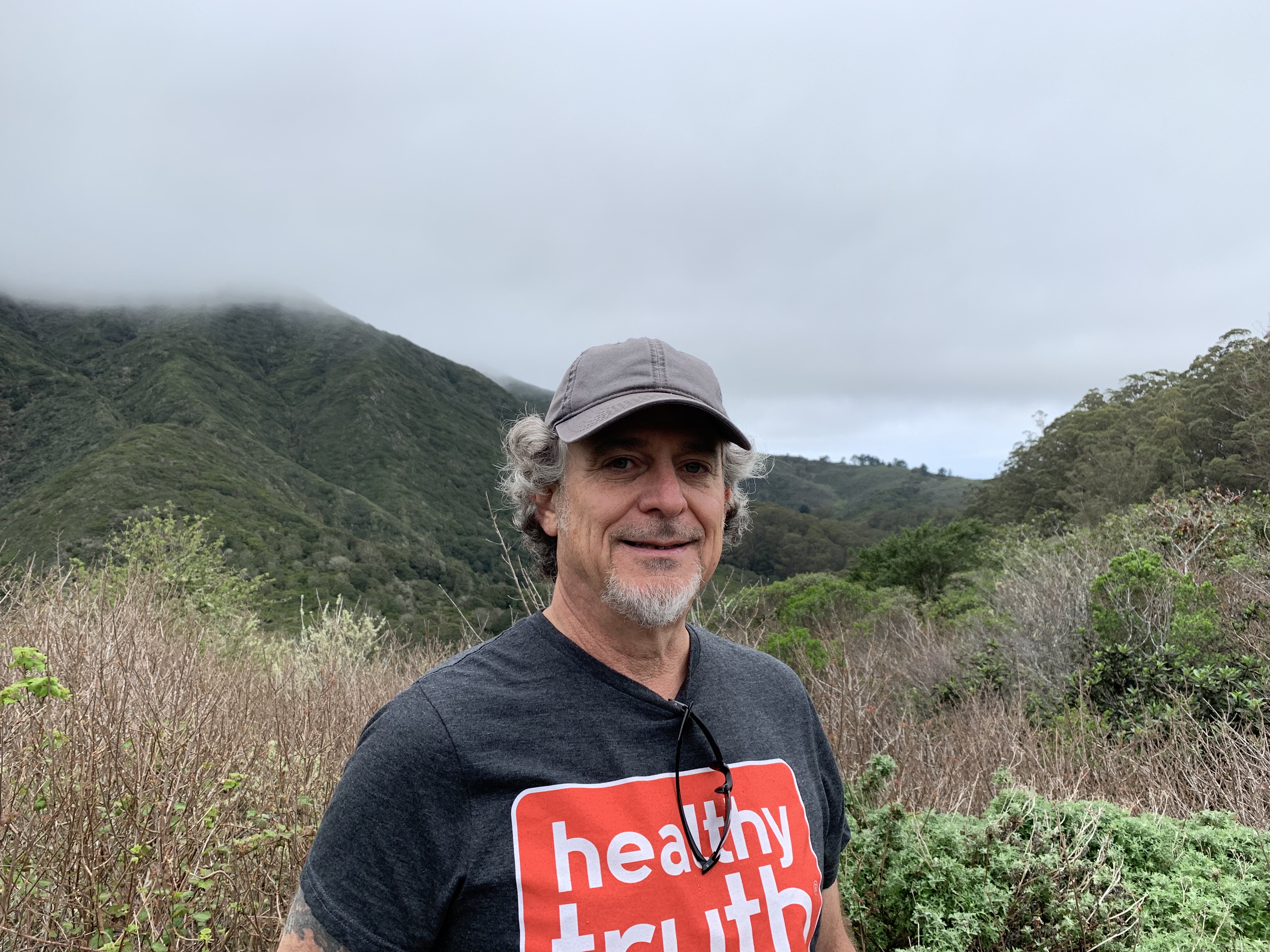 Ben in front of a beautiful coastal valley in the fog